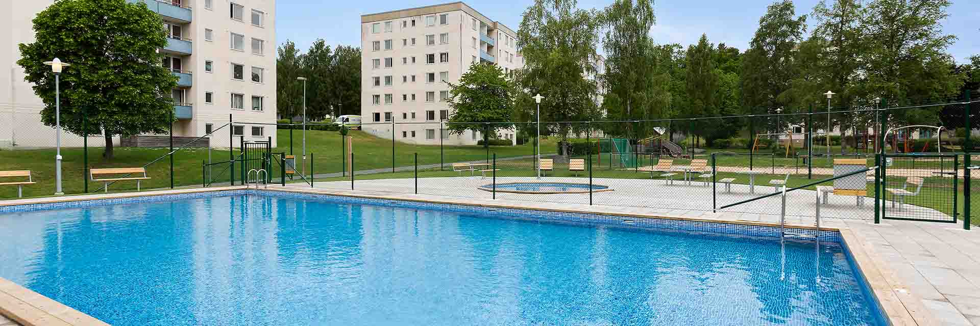 pool med träd och lägenheter i bakgrunden