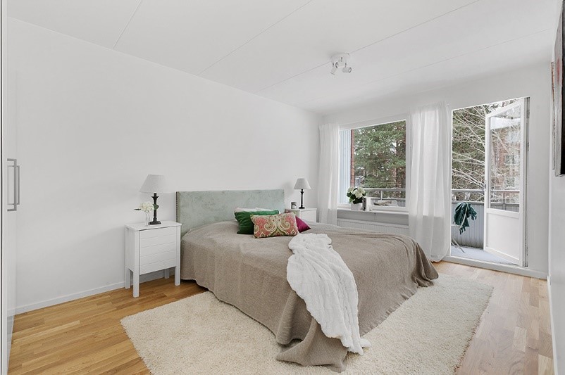 Ett generöst sovrum med garderober och balkong tillhörande modern lägenhet som är tillgänglig för uthyrning i Tranås.