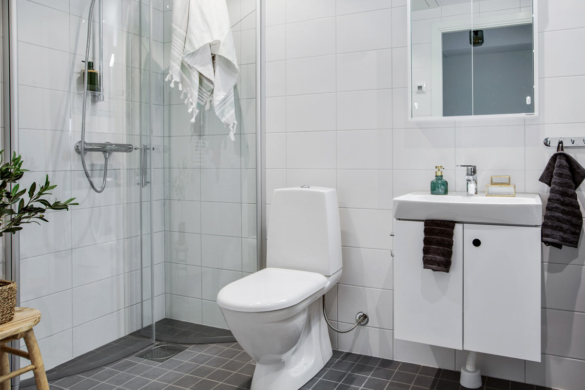 Ett helkaklat badrum tillhörande modern lägenhet med ett öppet kök och vardagsrum som är tillgänglig för uthyrning i Göteborg.
