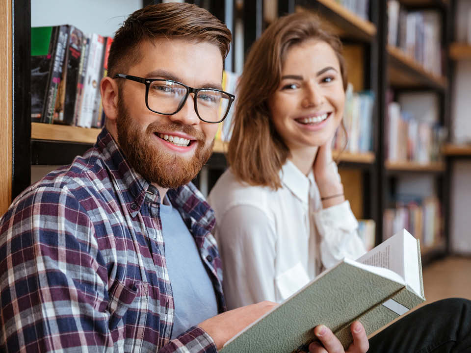Två personer pratar och läser bok